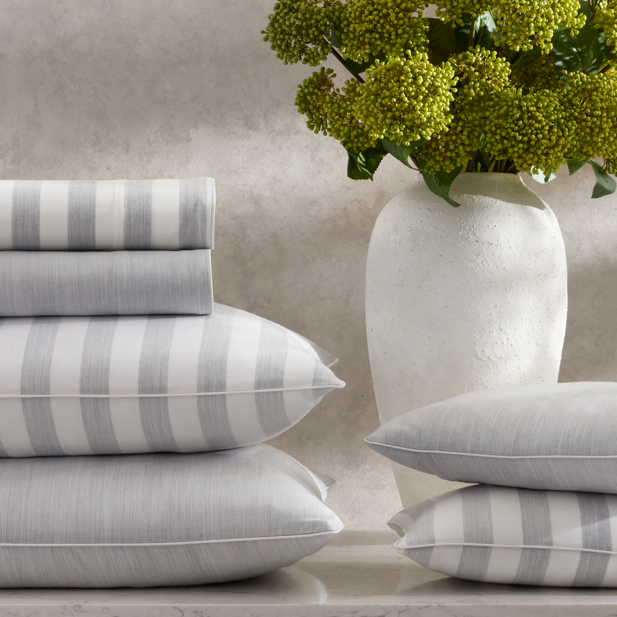 Stack of Matouk Lana Bedding in Silver and Silver Stripes colors
