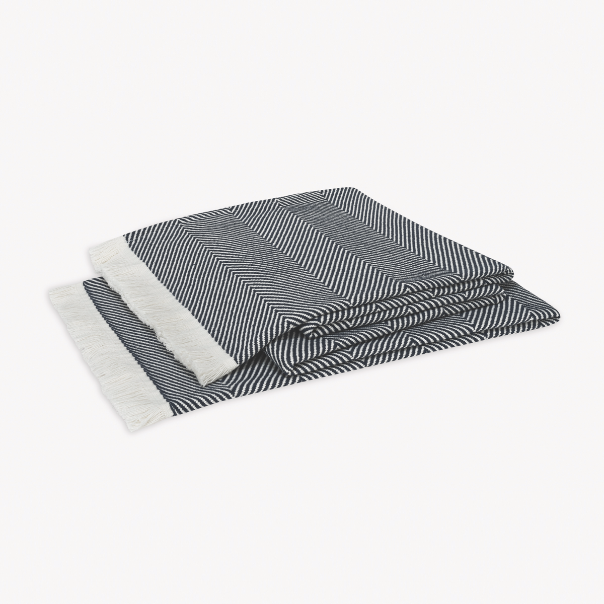 A folded Navy Matouk Leo Throw, a 100% cotton herringbone throw with fringed edges, rests on a plain white background