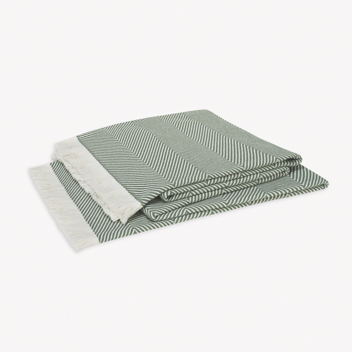 A folded Palm Matouk Leo Throw, a 100% cotton herringbone throw with fringed edges, rests on a plain white background