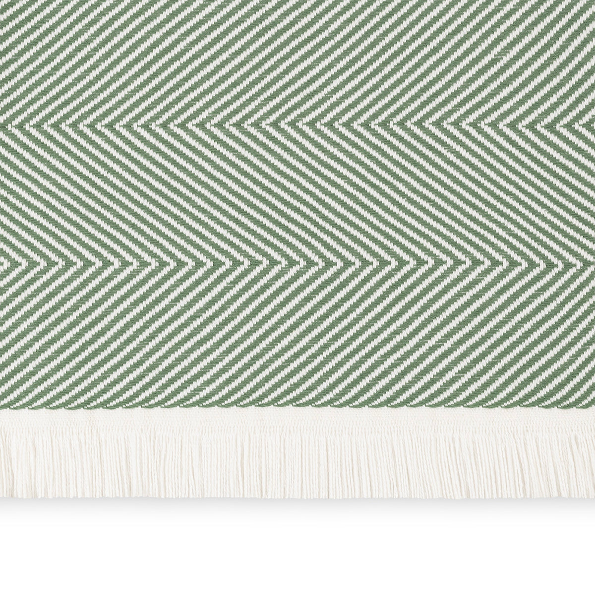A close-up of a Palm Matouk Leo Throw, a 100% cotton herringbone throw with fringe along the bottom edge