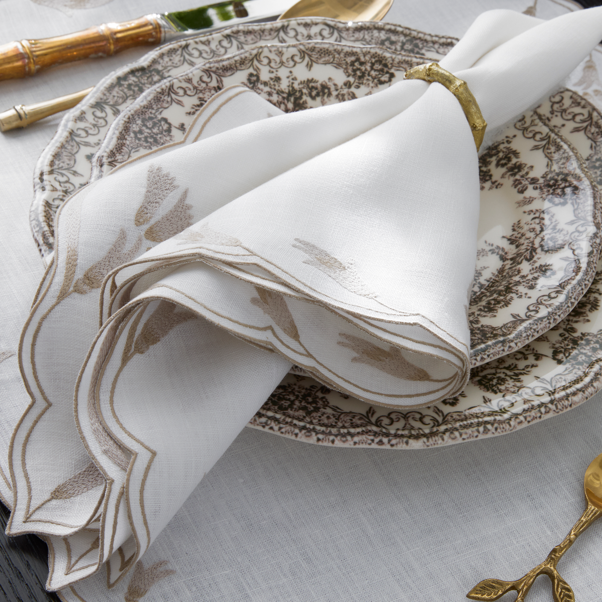 Rolled Matouk Marcella Dinner Napkins on a plate