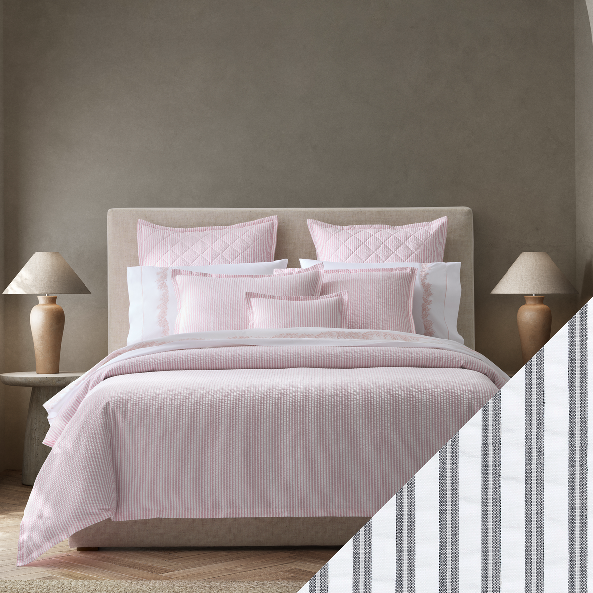 A neatly made bed with Pink Matouk Matteo seersucker bedding with Deepnavy Swatch