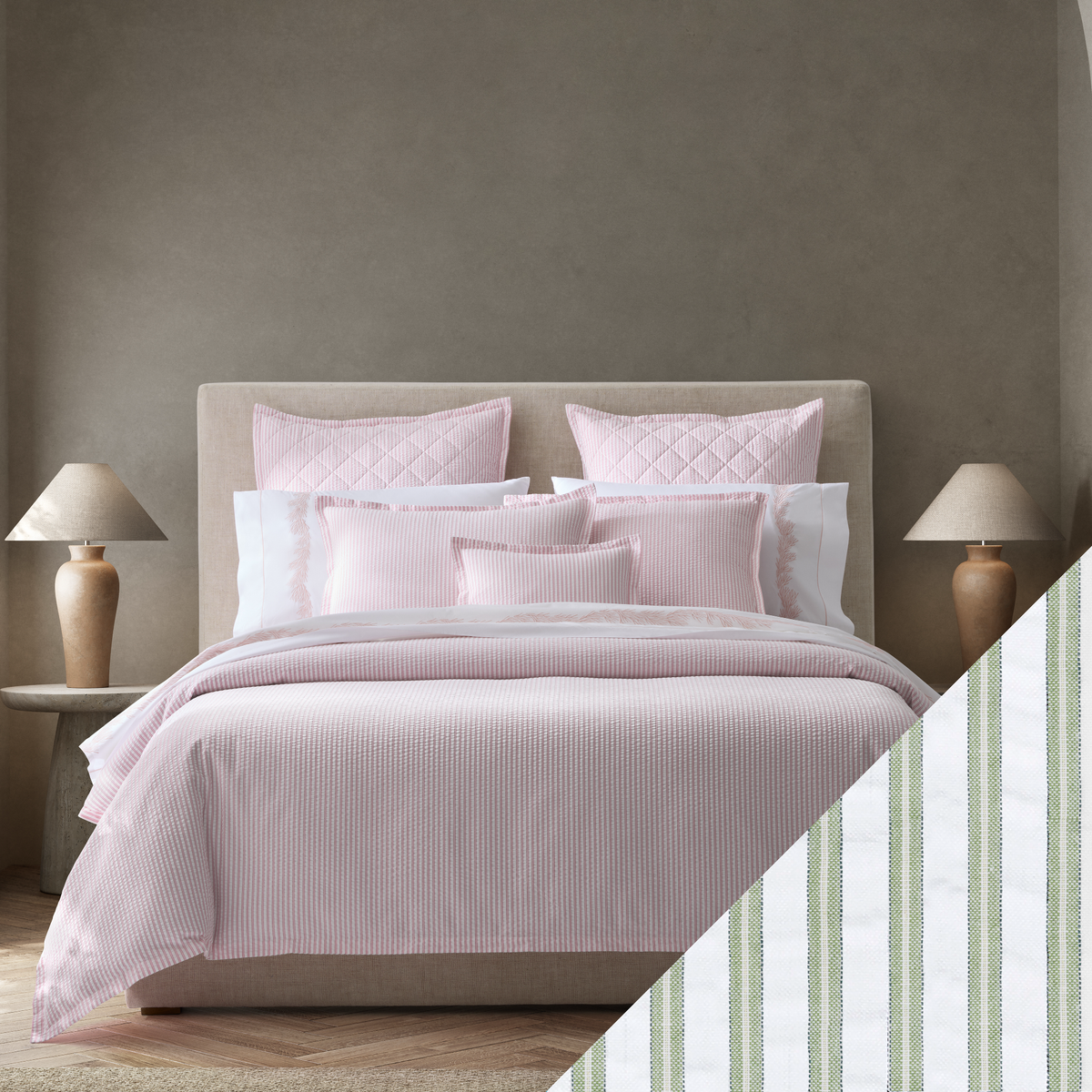 A neatly made bed with Pink Matouk Matteo seersucker bedding with Palm Swatch