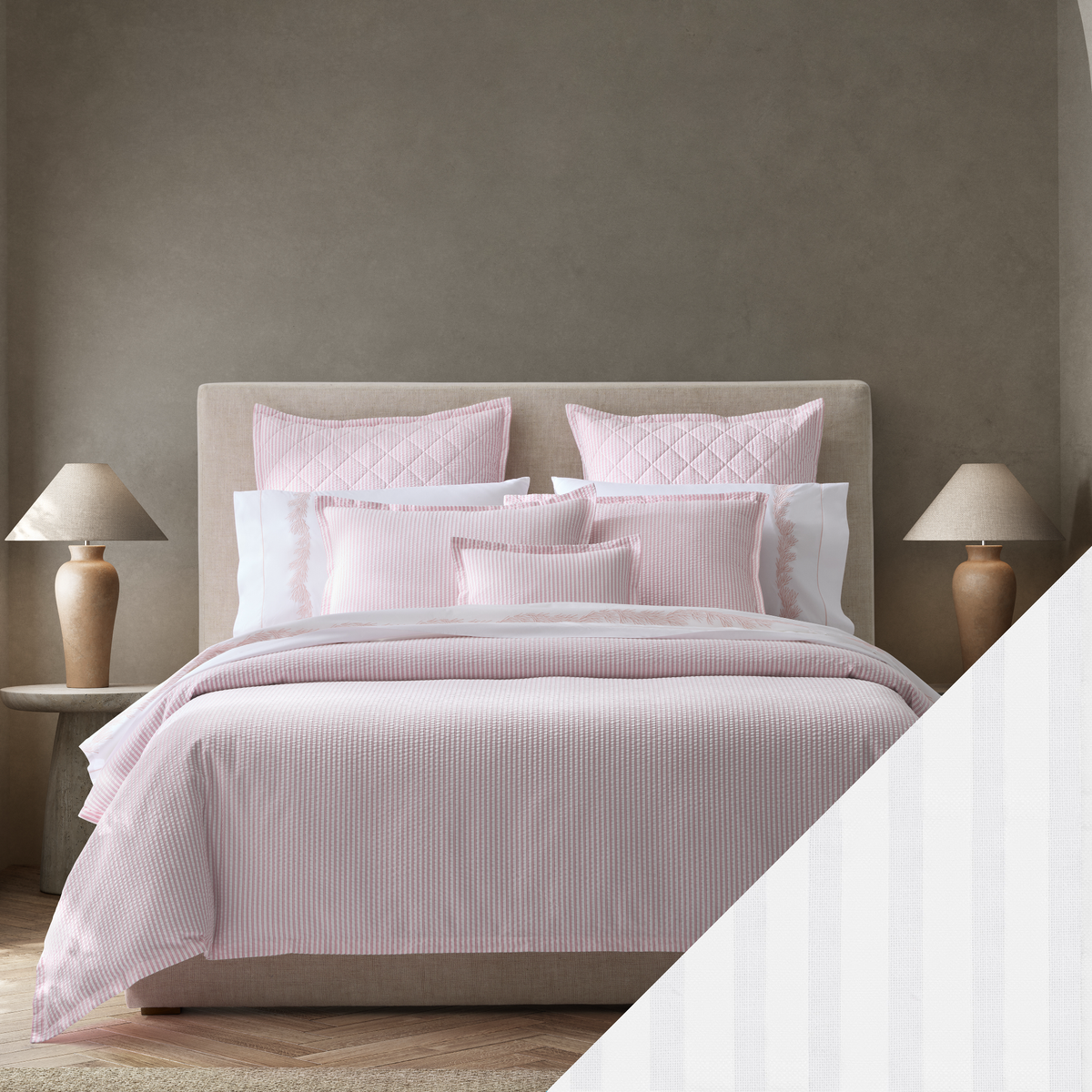A neatly made bed with Pink Matouk Matteo seersucker bedding with White Swatch