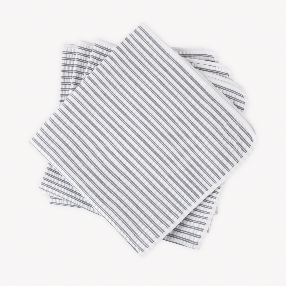 Four neatly stacked Matouk Matteo Table Napkins in Deep Navy color