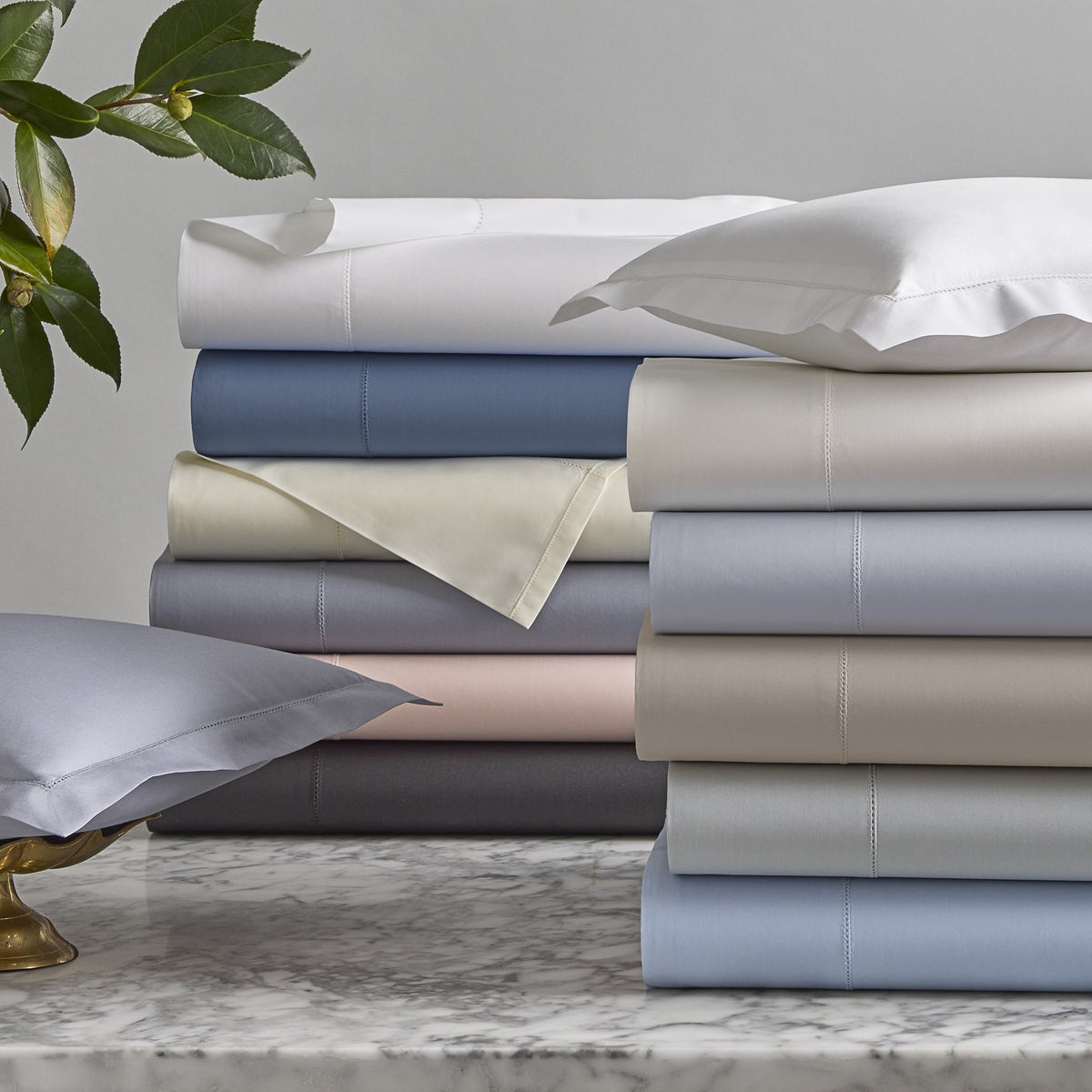 Stack of Matouk Milano Hemstitch Bedding in Different Colors