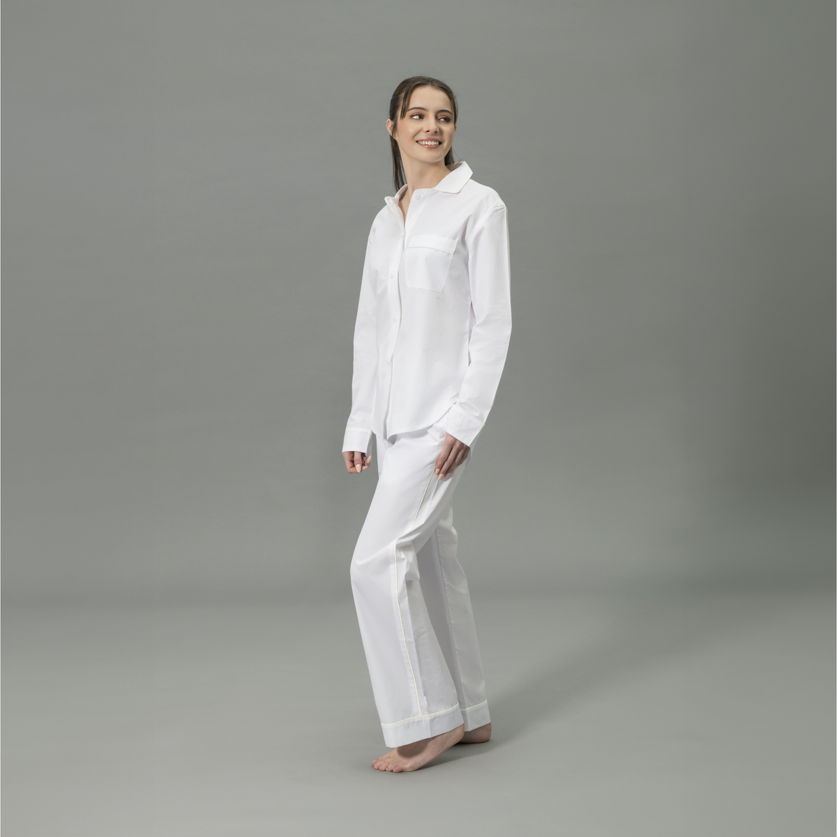 Side View of Model Wearing Matouk Milano Pajama Set in Color Ivory