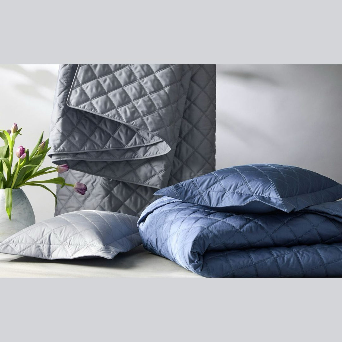 A collection of Dove, Elephant and Steel Blue colors from the Matouk Milano Quilted Bedding