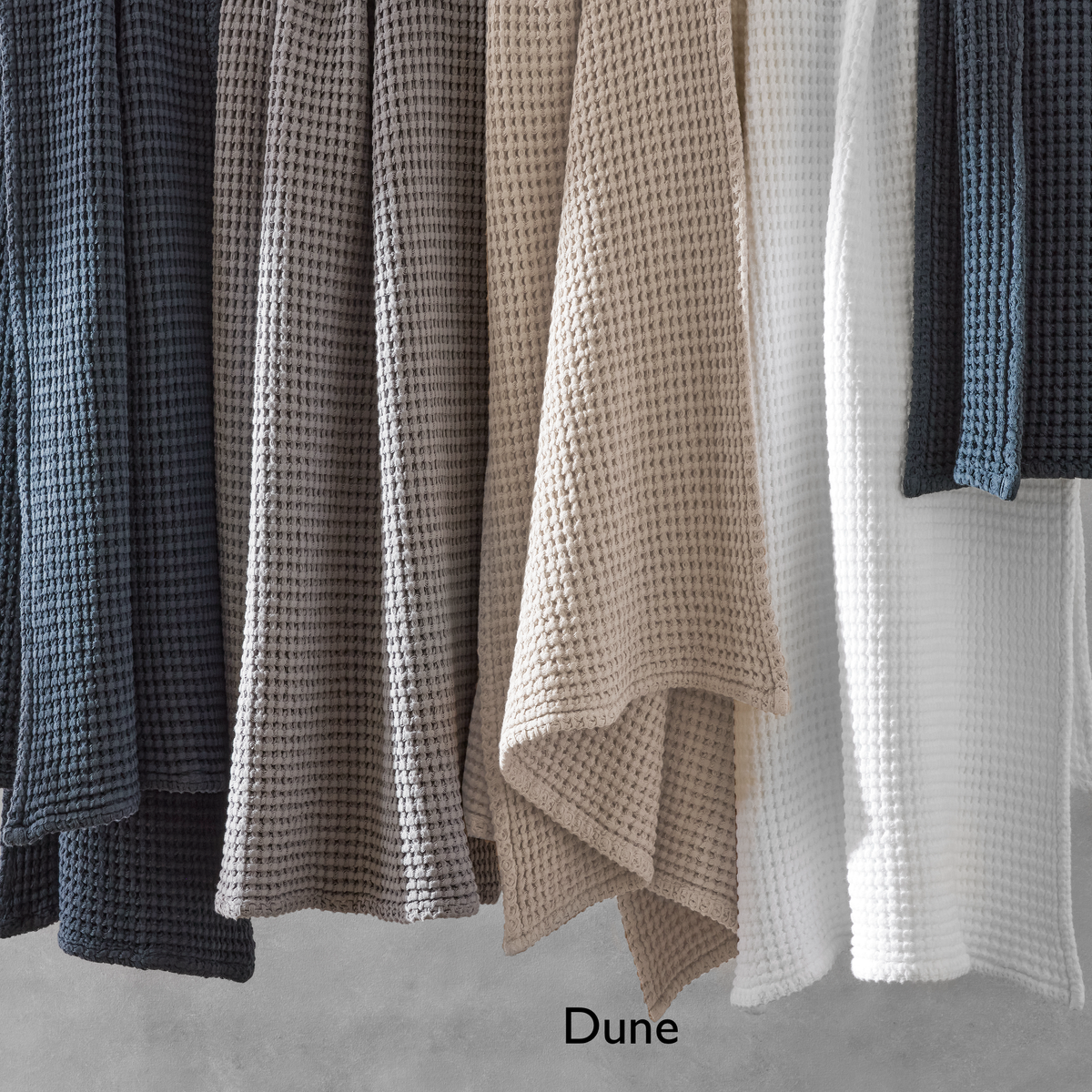 Hanging White Matouk Nico Bath Towels with Dune text label