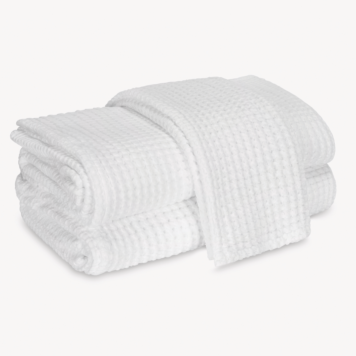 A neatly folded white waffle towel, made from 100% cotton, on a plain white background.