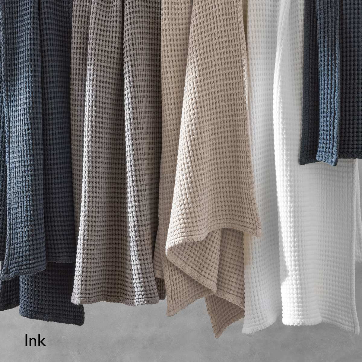 Hanging White Matouk Nico Bath Towels with Ink text label