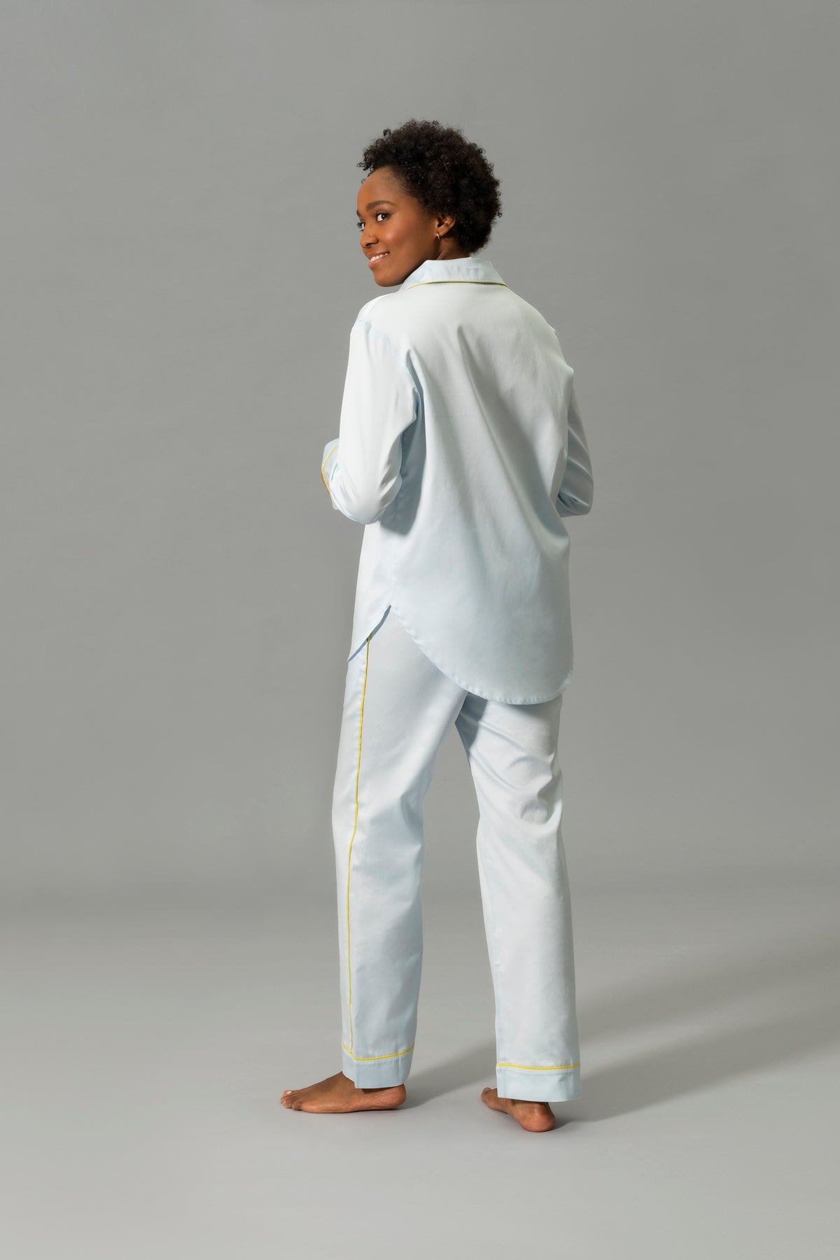 Back View of Model Wearing Matouk Nocturne Pajama Set in Color Blue and Lemon
