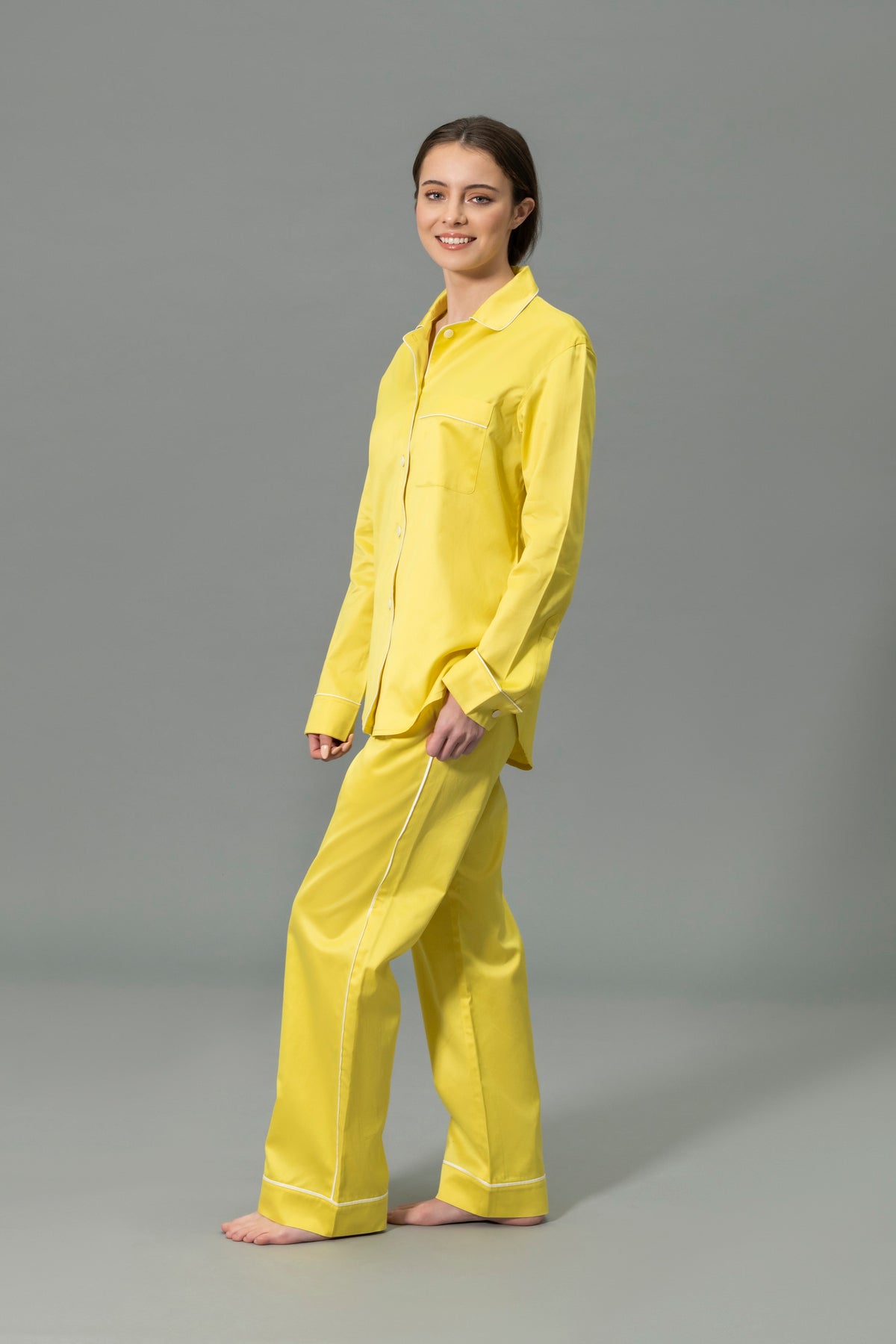 Side View of Model Wearing Matouk Nocturne Pajama Set in Color Lemon and Bone