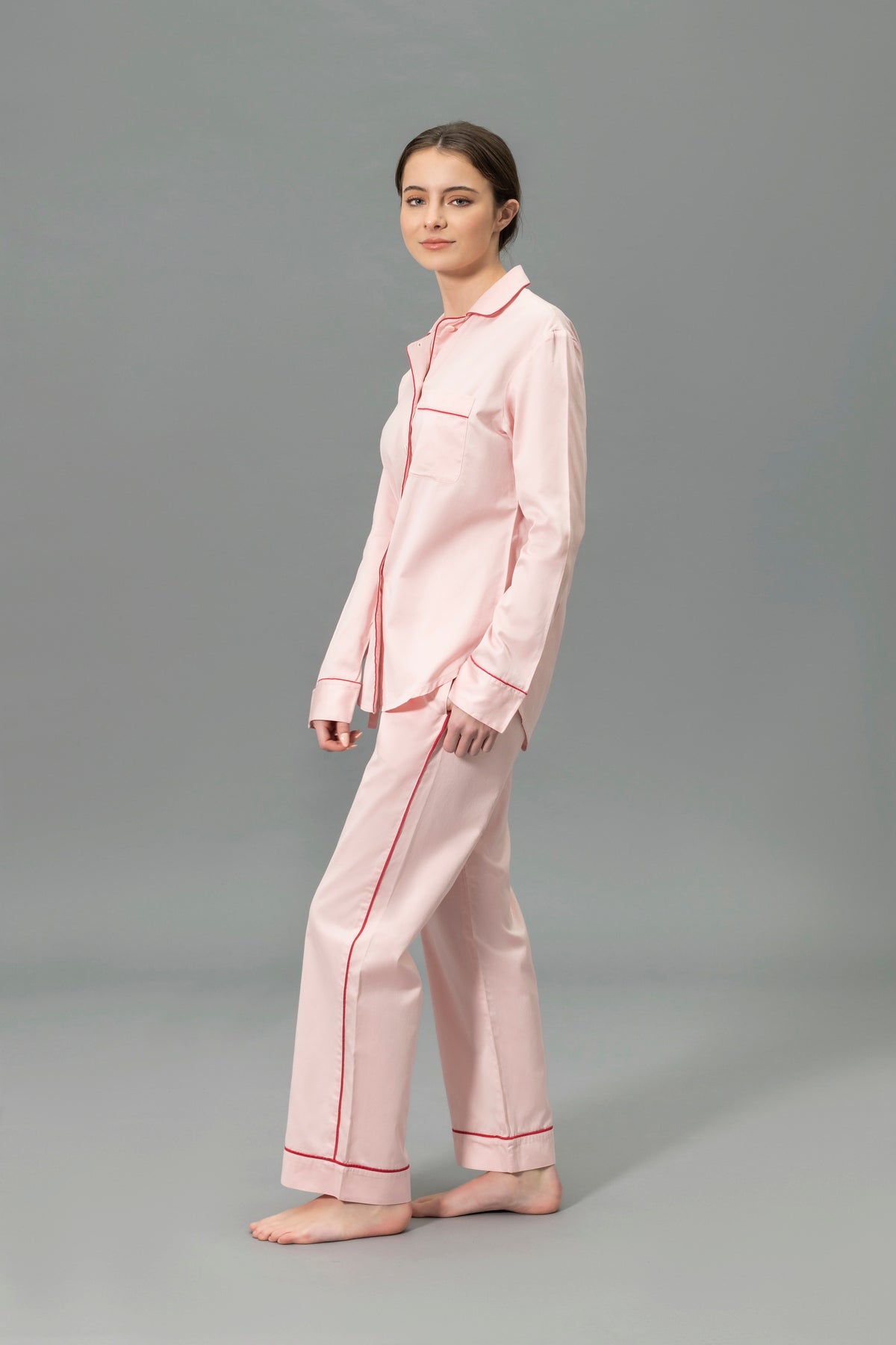Side View of Model Wearing Matouk Nocturne Pajama Set in Color Pink and Scarlet