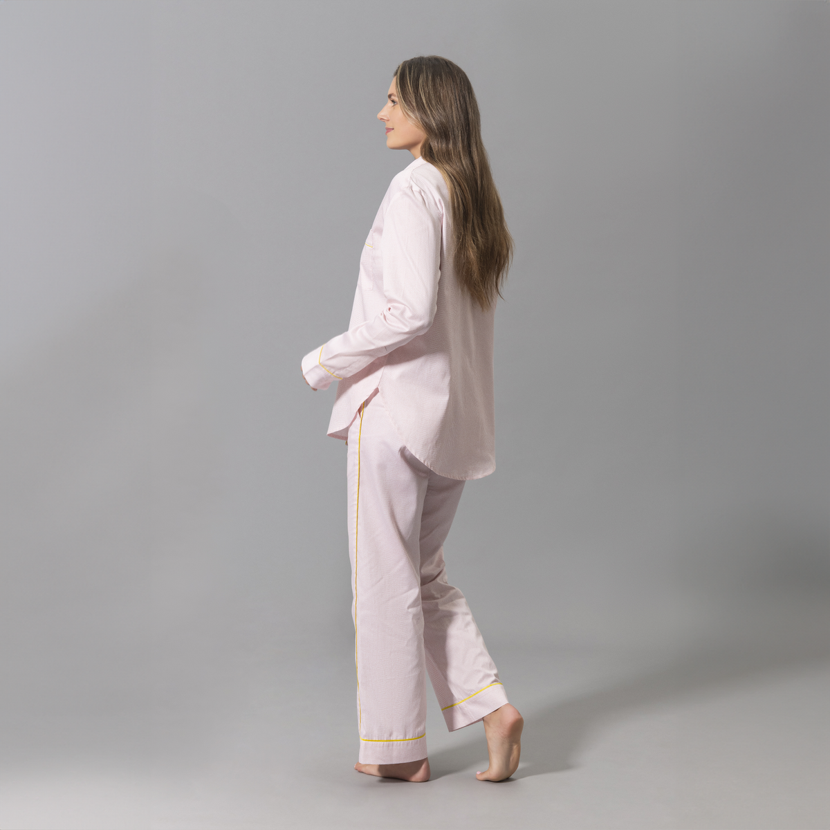 Side Angle of a Woman Wearing a Matouk Jasper Pajama Set in Peony and Lemon Color