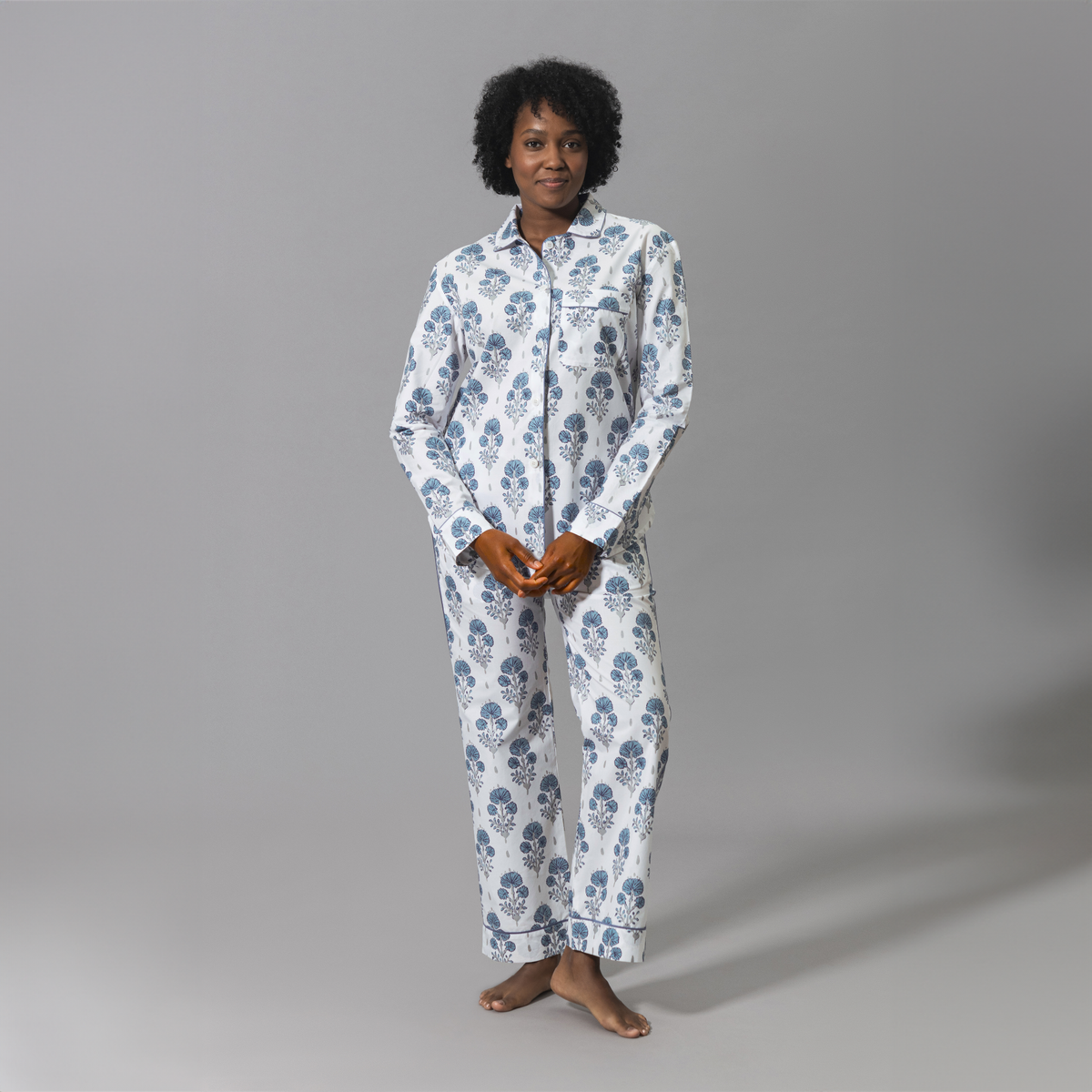 Smiling Woman Wearing a Lulu DK Matouk Joplin Pajama Set in Mineral Blue