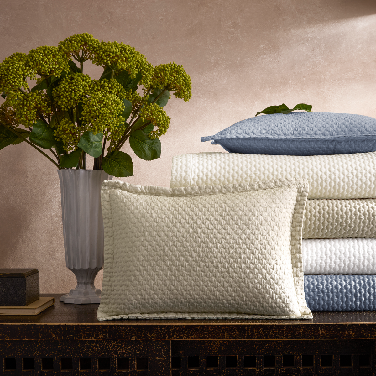Stack of Matouk Perla Bedding Shams and Folded Sheets in different colors