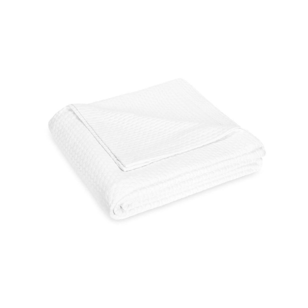 A neatly folded white textured blanket, crafted from 100% cotton, with a corner turned down for a luxury bedding touch.