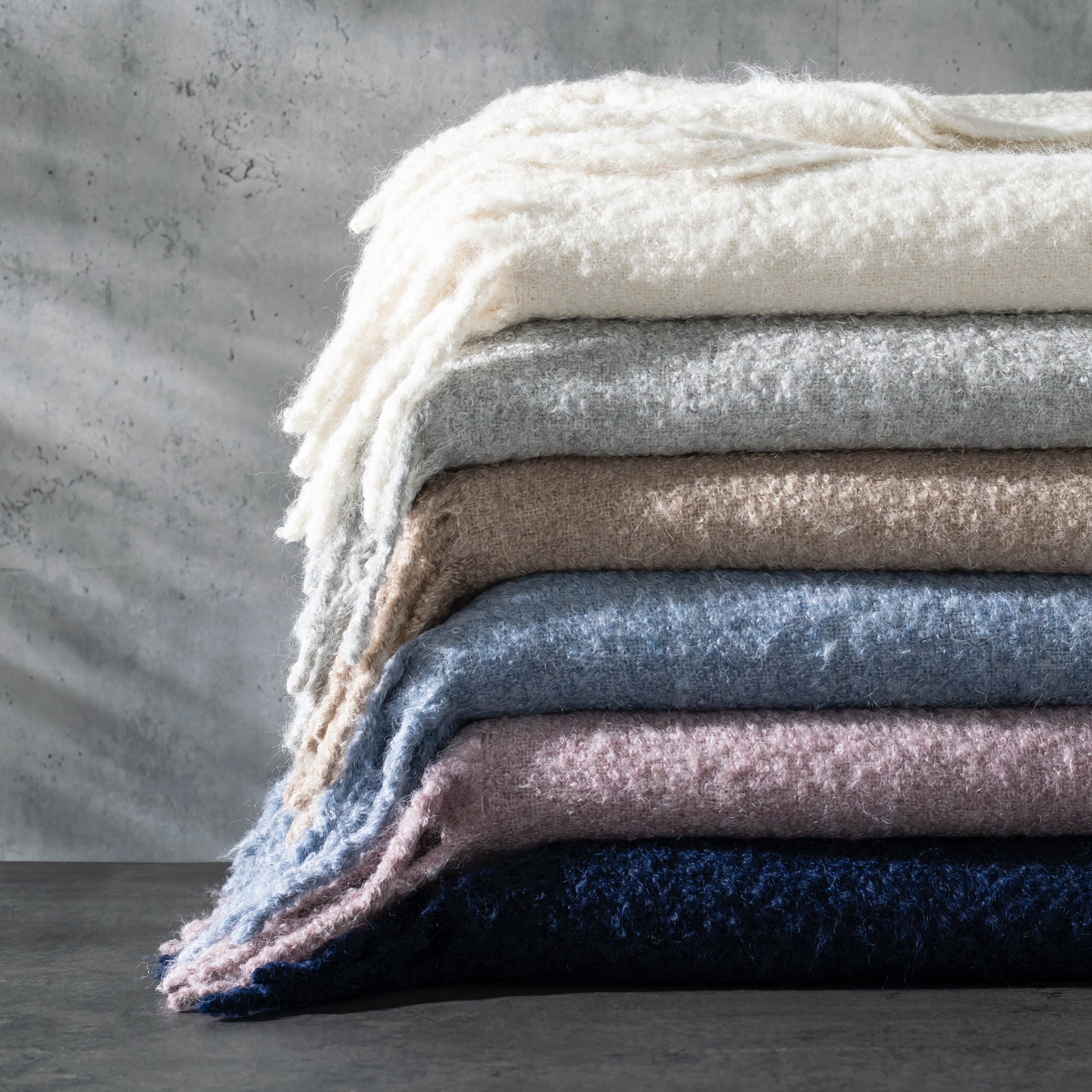 Stack of Matouk Poncho Throws in All Colors