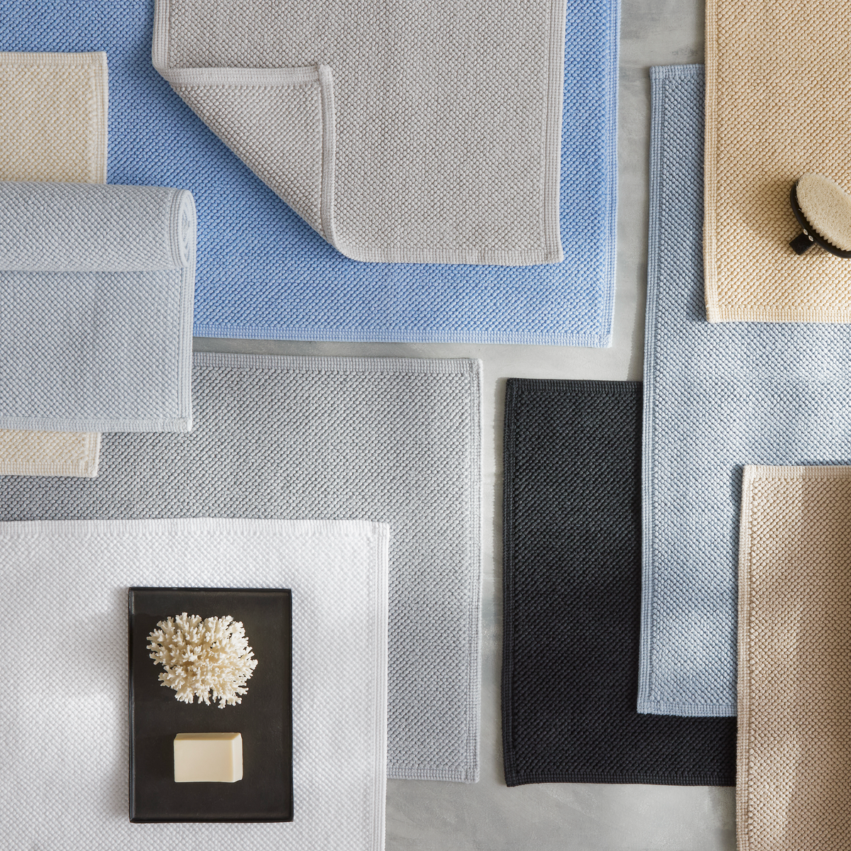 Several Matouk Reverie bath rugs in 2026 colors feature non-slip backing and zero-twist cotton softness.