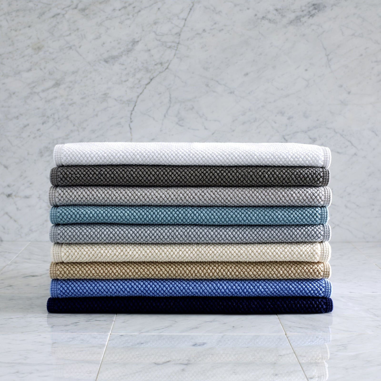 Stack of Matouk Reverie Bath Rugs