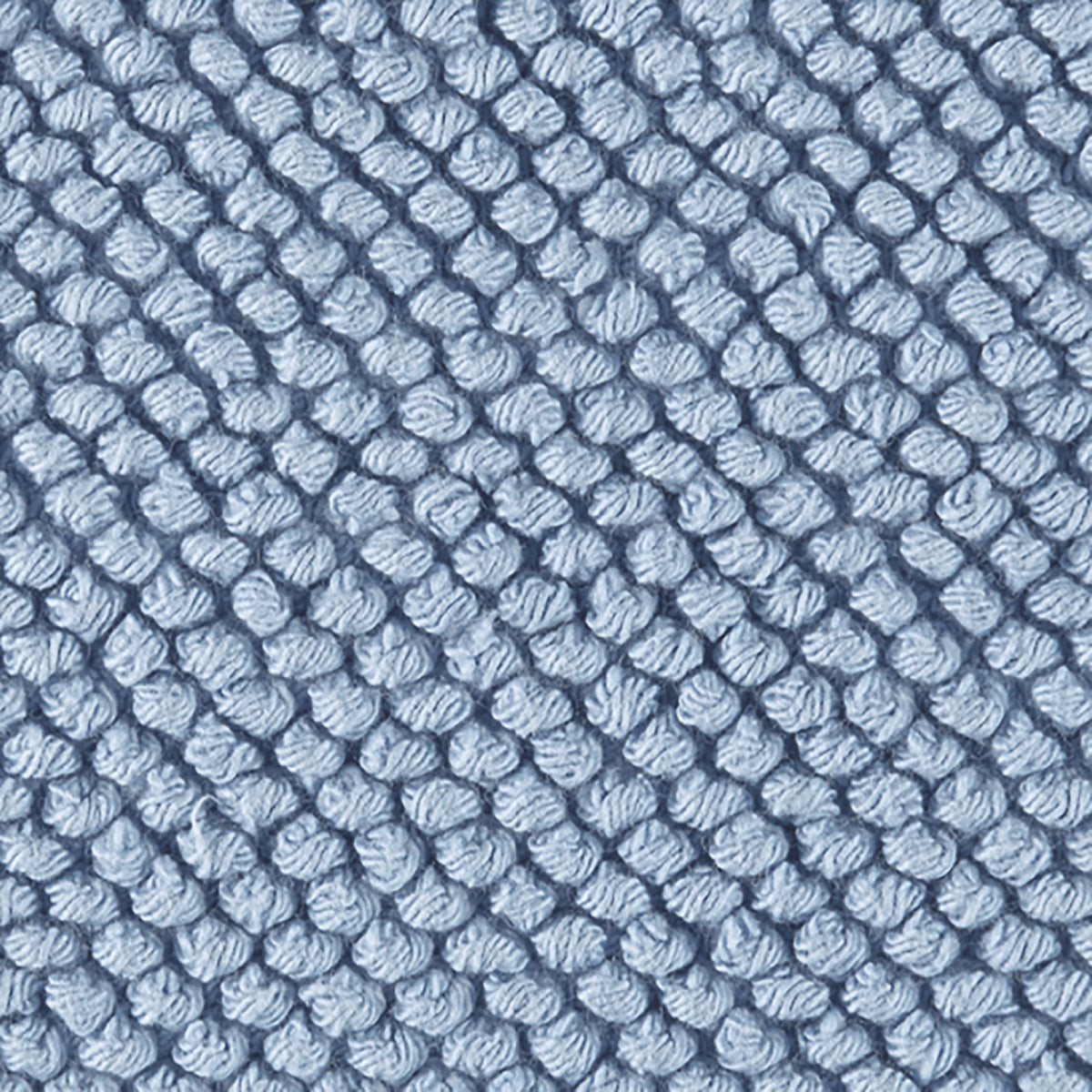 Close-up of a hazy blue, textured woven fabric of the Matouk Reverie bath rug