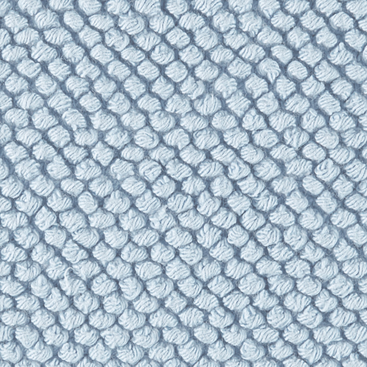 Close-up of a light blue, textured woven fabric of the Matouk Reverie bath rug