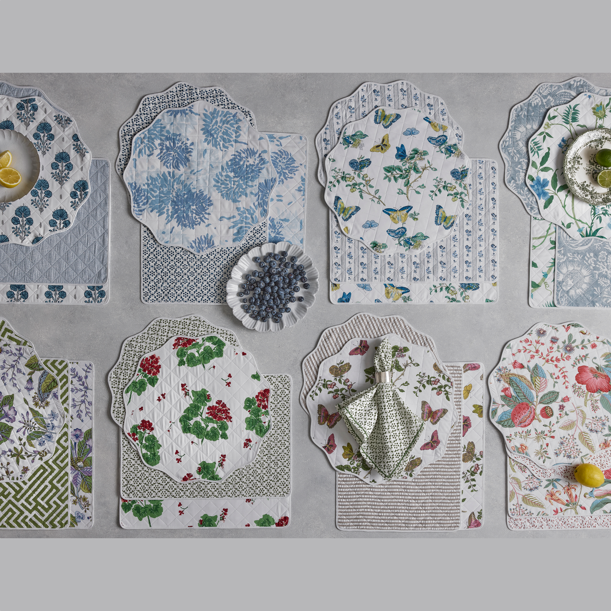 Reversible Quilted Placemat in Joplin Mineral Blue/Jasper Hazy Blue, Chrysanthemum Blue/Laksha Indigo, Baudin Blue/Cabanon Blue, Palmyra Emerald/Granada Hazy Blue, Pomegranate Lilac/Gabriel Grass, Geranium Scarlet/Laksha Moss, Baudin Pink/Matteo Bark, and Pomegranate Pink/Celine Redberry
