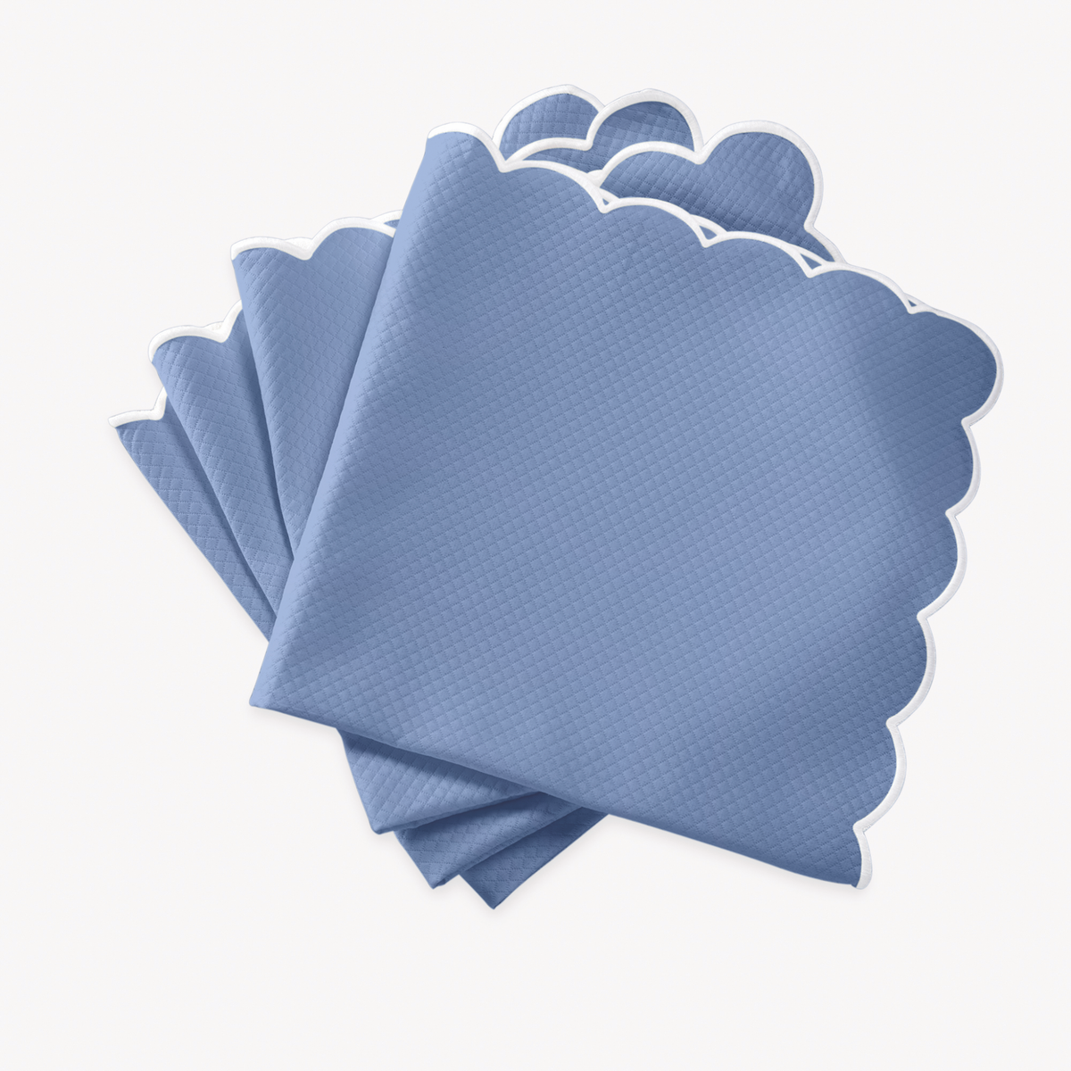 Azure napkins with scalloped edges of Matouk Savannah Gardens table linens