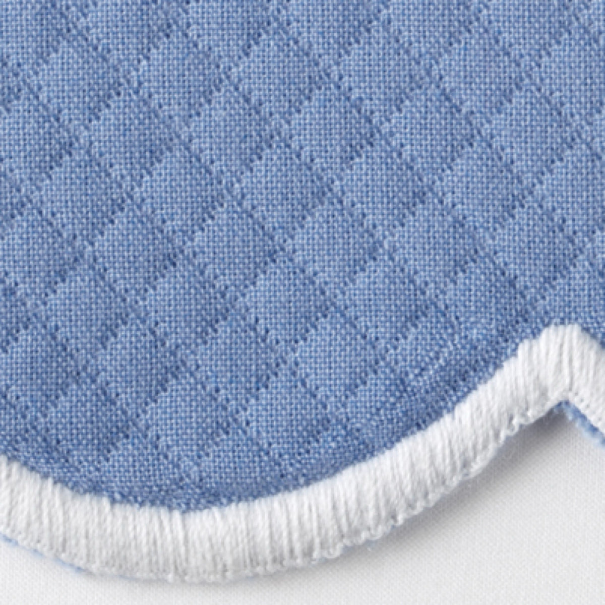 Close-up of Azure Matouk Savannah Gardens diamond pique table linens