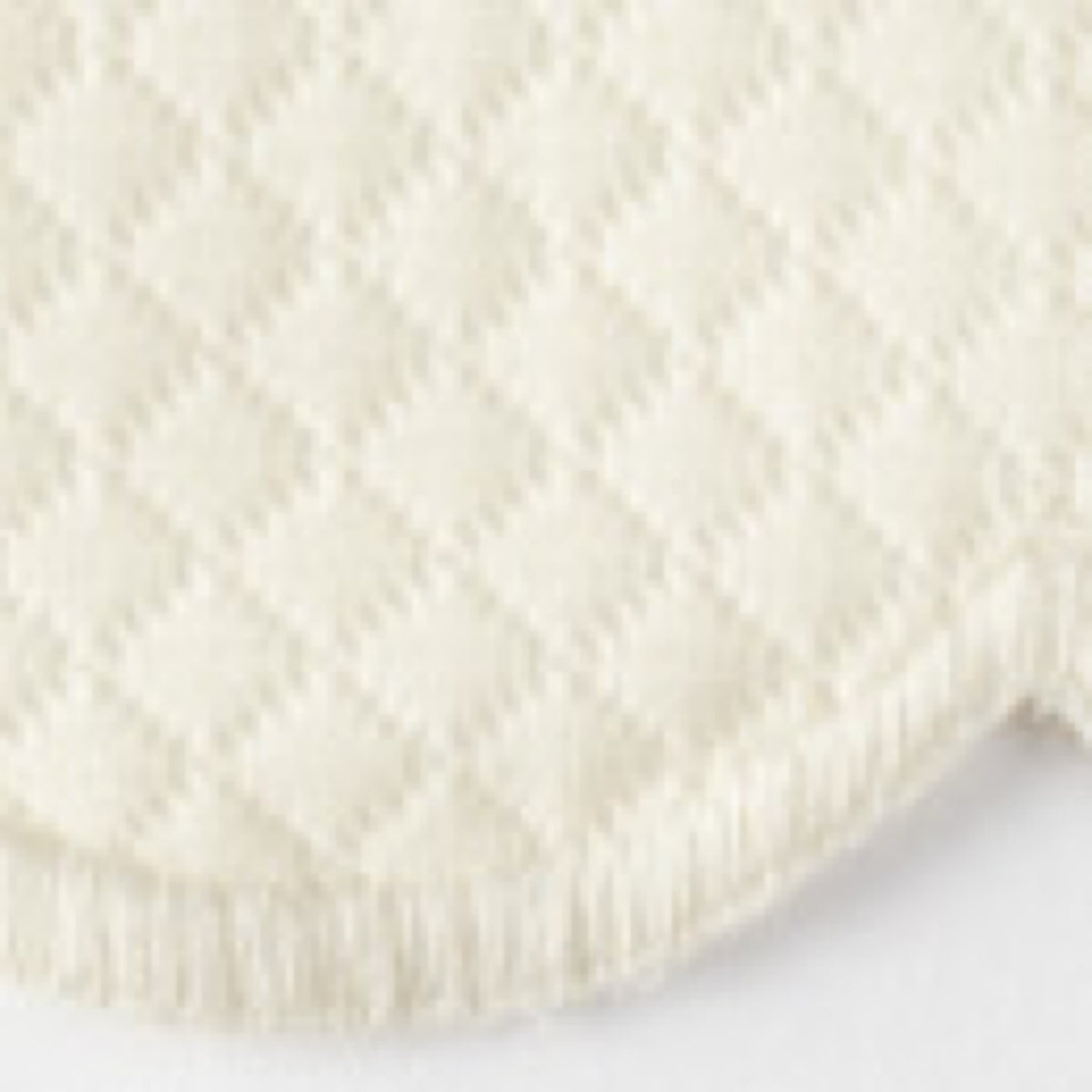 Close-up of Ivory Matouk Savannah Gardens diamond pique table linens