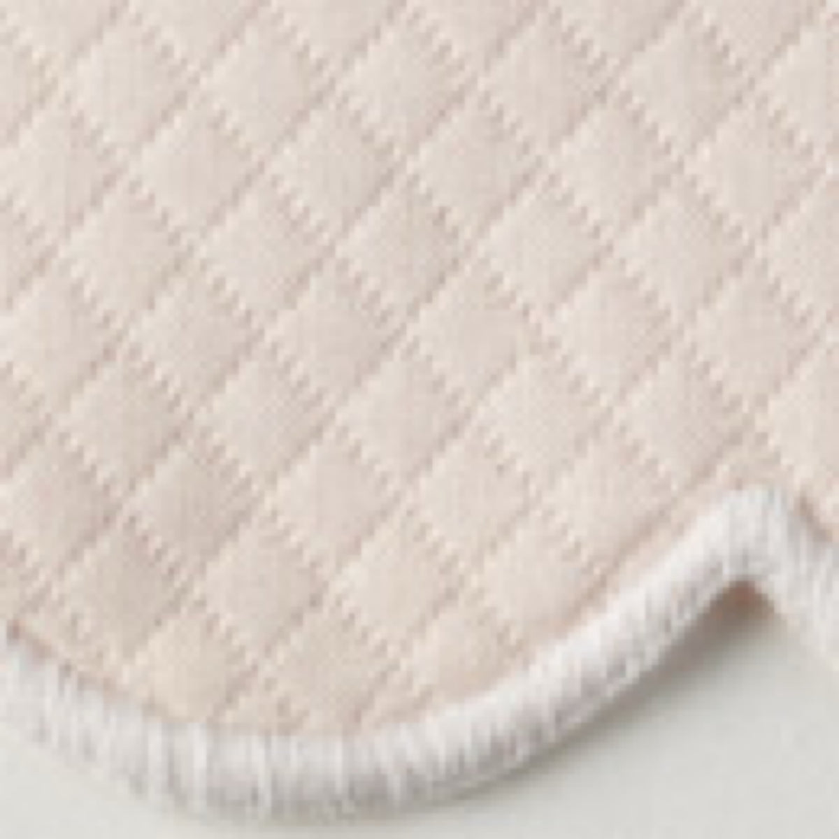 Close-up of Pink Matouk Savannah Gardens diamond pique table linens