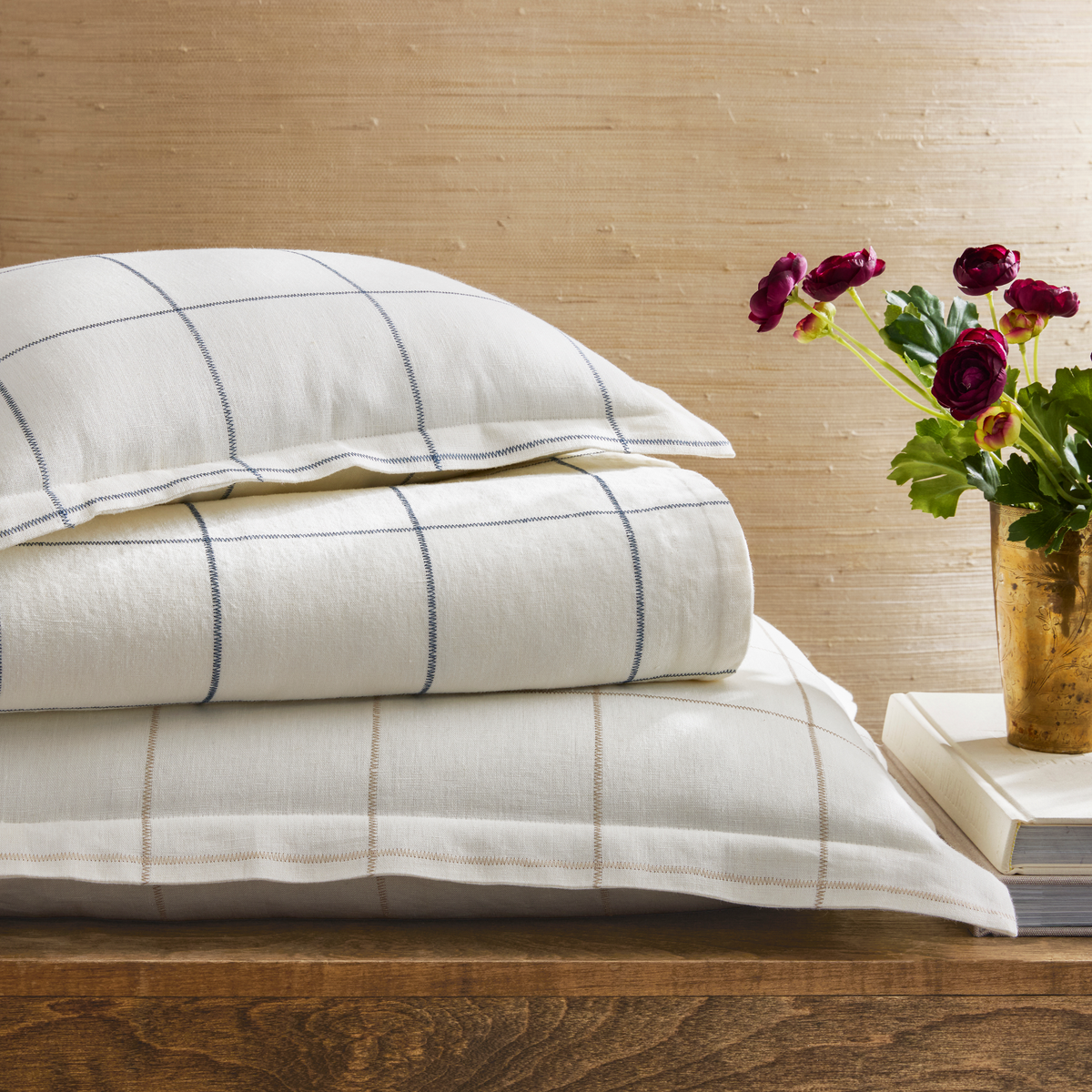 Stack of Matouk Schumacher Sebastian Bedding in Navy and Dune colors