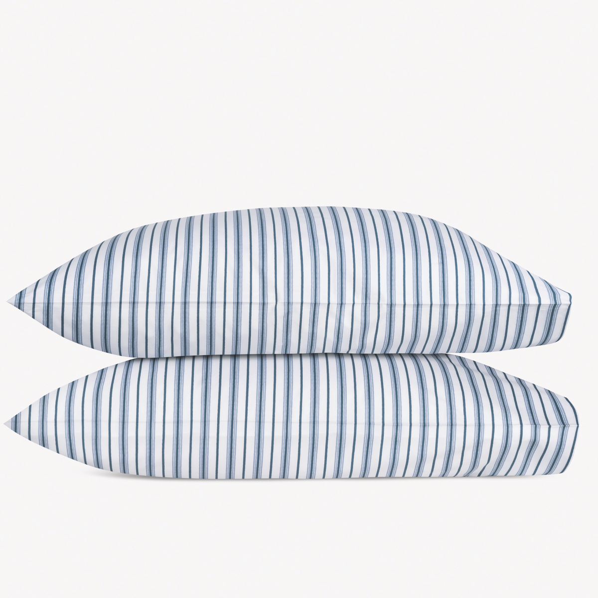 Two Prussian Blue Matouk Calypso Pillowcases stacked against a plain background
