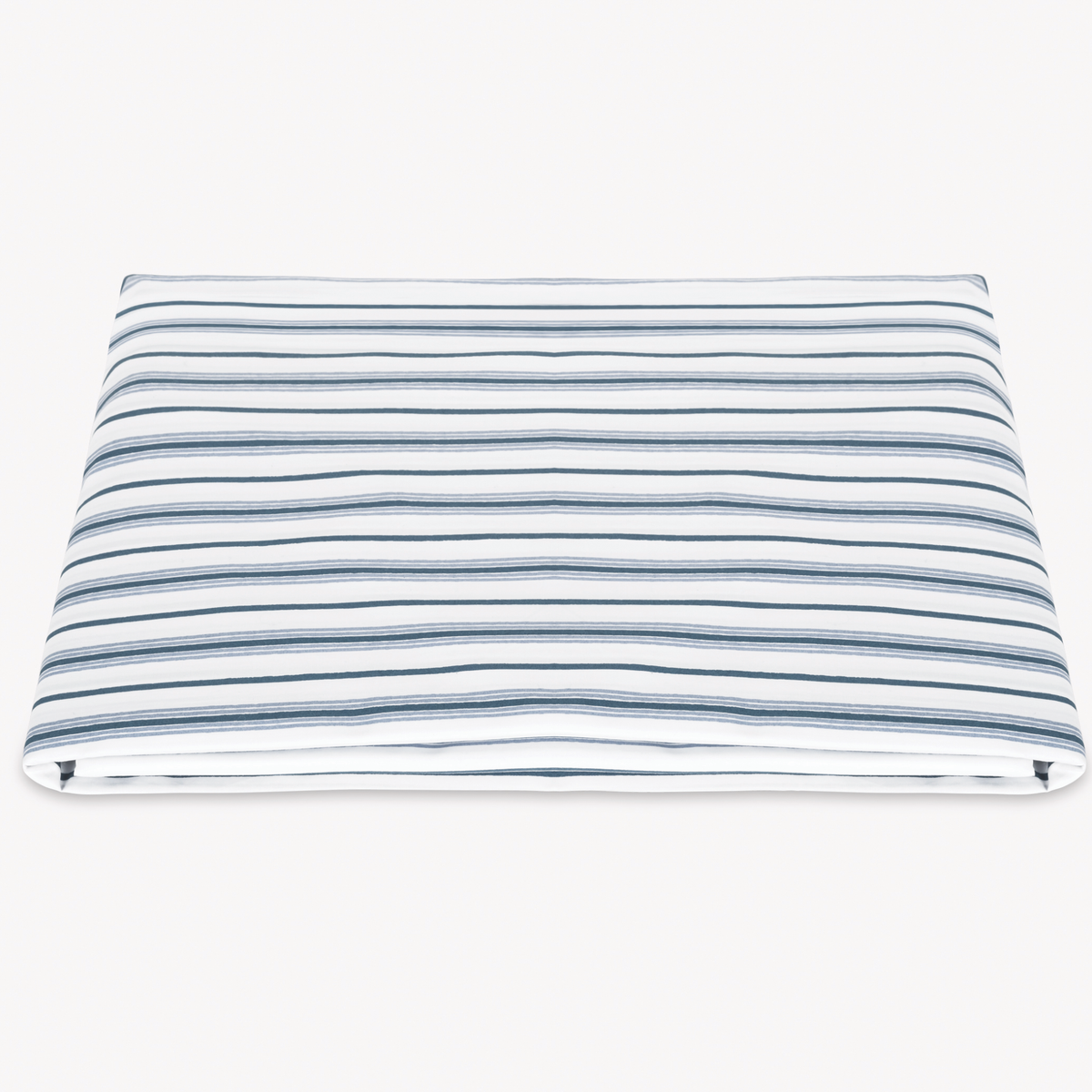 A neatly folded Matouk Calypso Bedding Fitted Sheet with Prussian Blue stripes