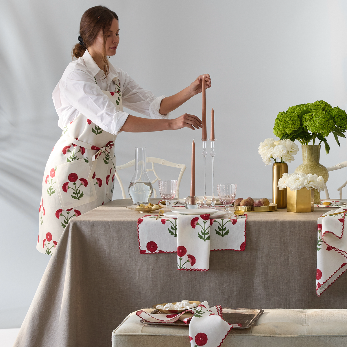 Kitchen Lifestyle Shot of Matouk Schumacher Linen Apron in Gisele Scarlet Pattern with Model