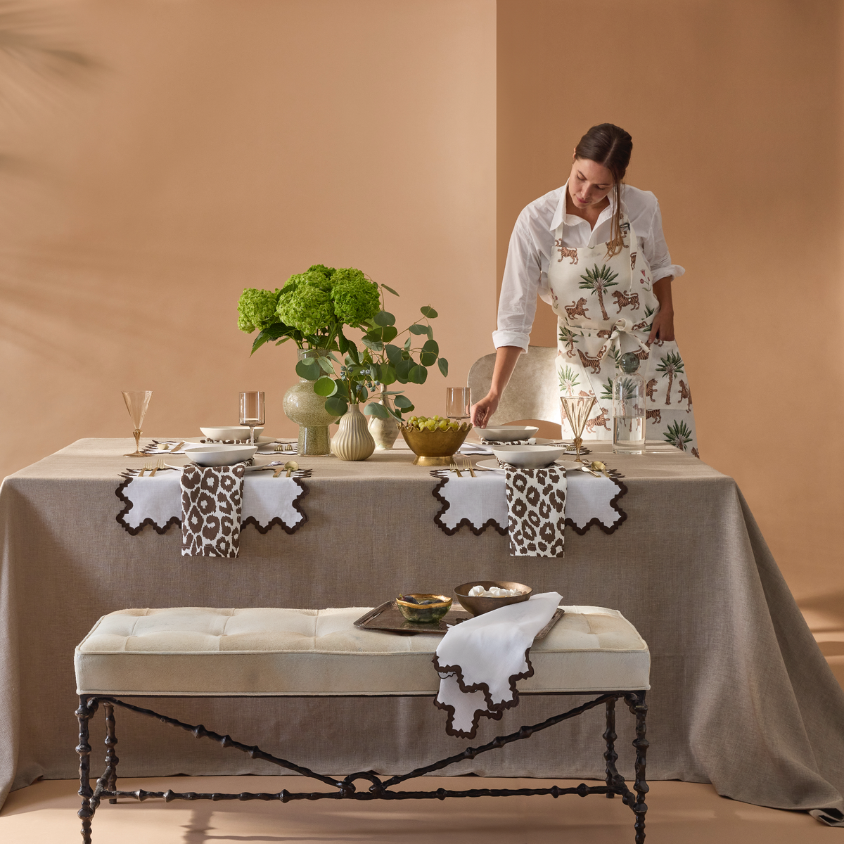 Kitchen Lifestyle Shot of Matouk Schumacher Linen Apron in Tiger Palm Tigereye Pattern with Model