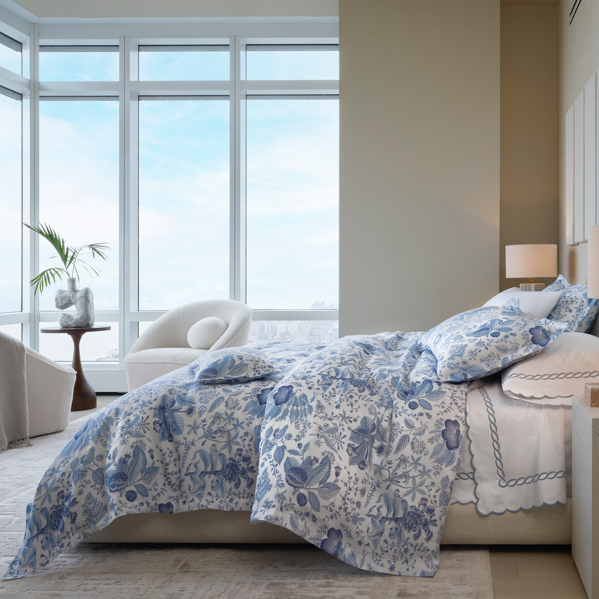 Lifestyle Picture of Sideview Full Bed of Matouk Schumacher Pomegranate Linen Bedding in Porcelain Blue Color