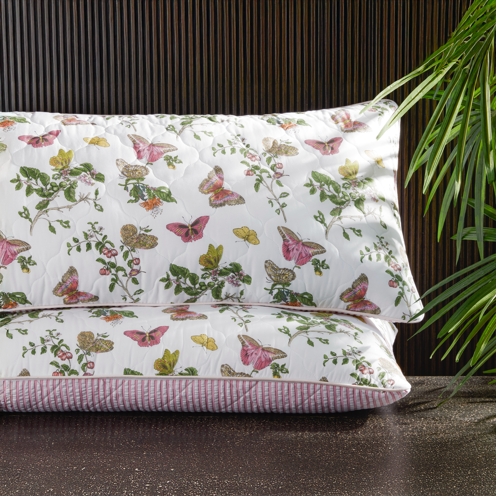 Stack of Matouk Schumacher Reversible Pillow Collection in Baudin Butterfly Pink/Matteo Peony