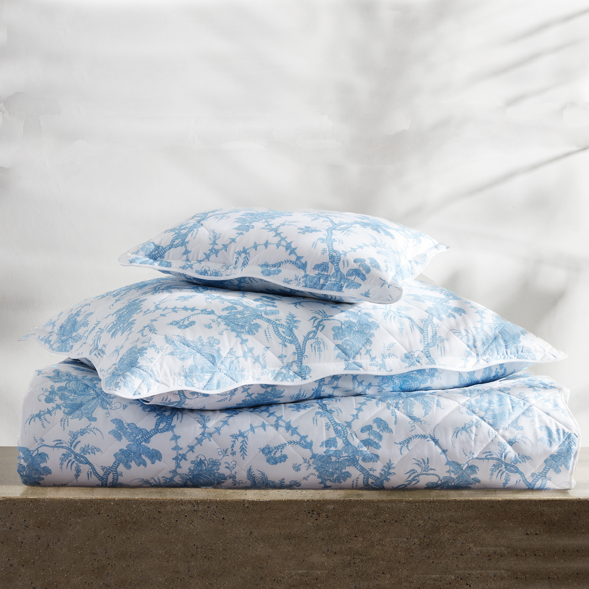 Stack of Quilted Matouk Schumacher San Cristobal Bedding in Sky Color