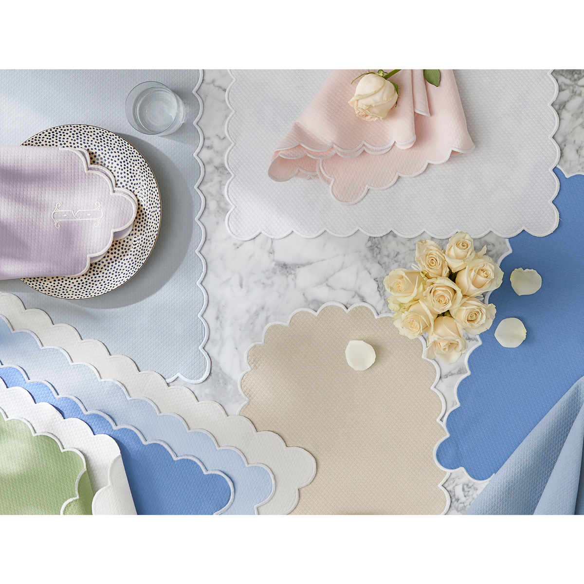 2026 colors of Scalloped Matouk Savannah Gardens cotton polyester table linens are paired with pale yellow roses on a marble surface