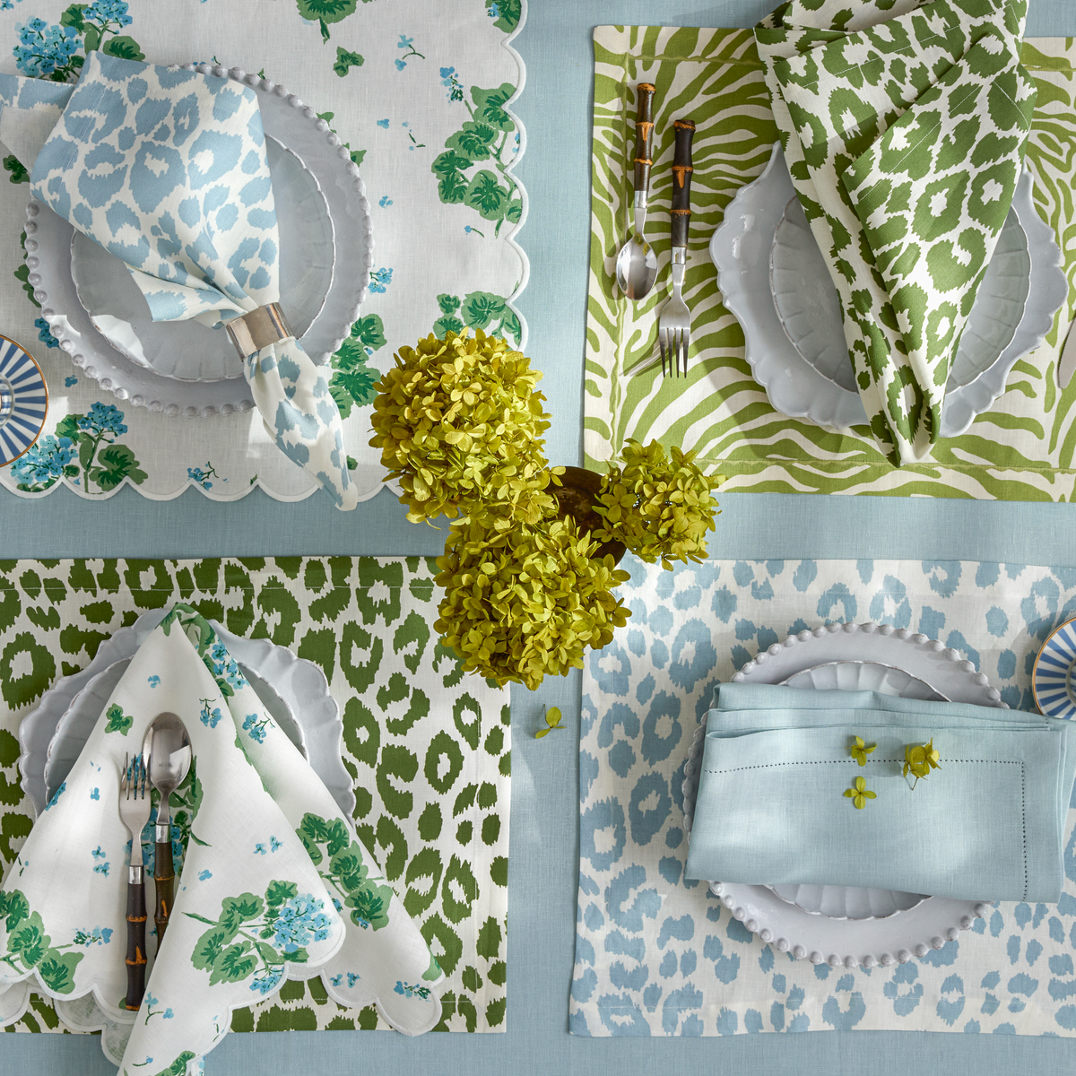 Matouk Geranium in Blue shown with Iconic Leopard in Sky and Green,
Regine in Grass, and Valentina Hemstitch in Sky