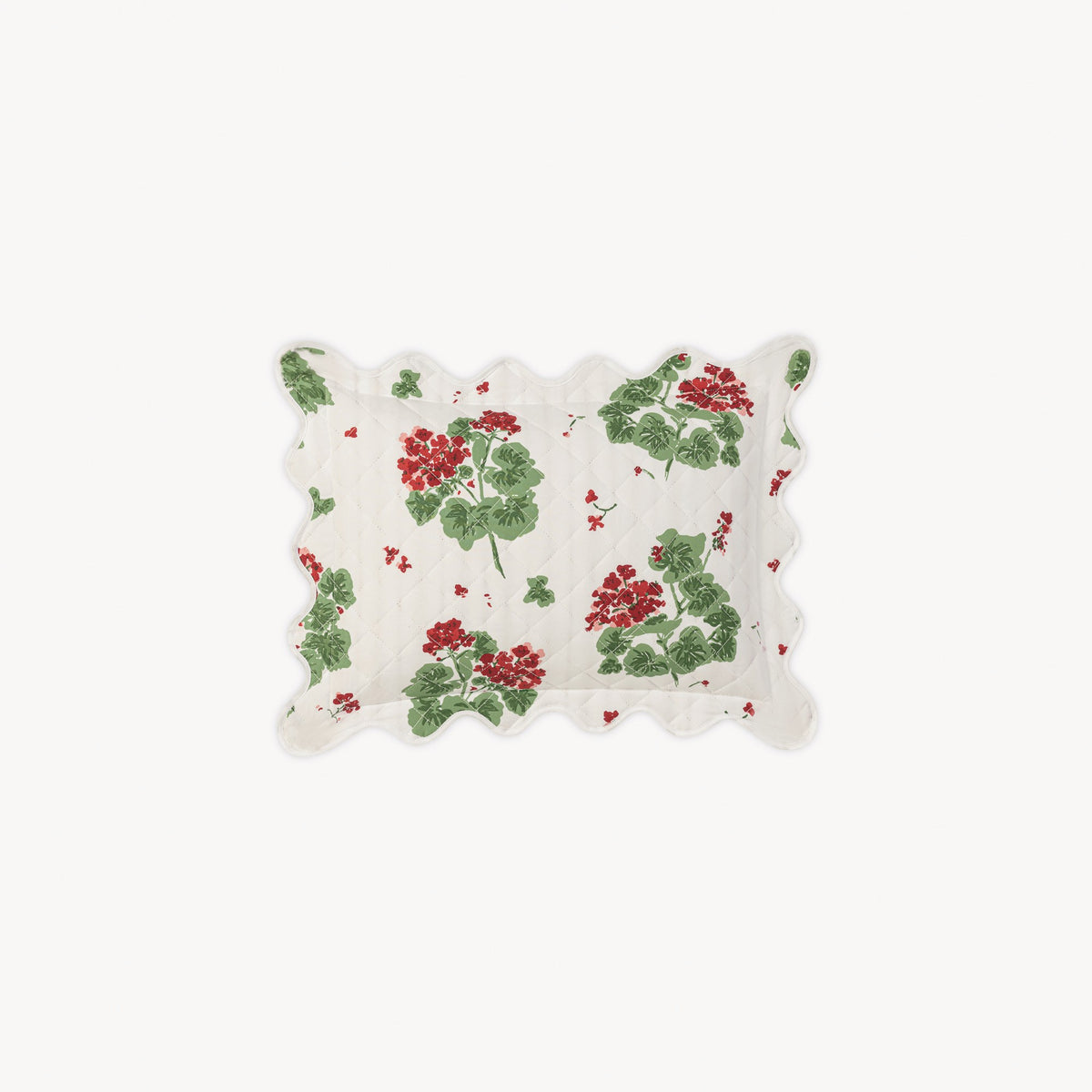 Decorative white quilted boudoir sham with red and green floral pattern on a white background