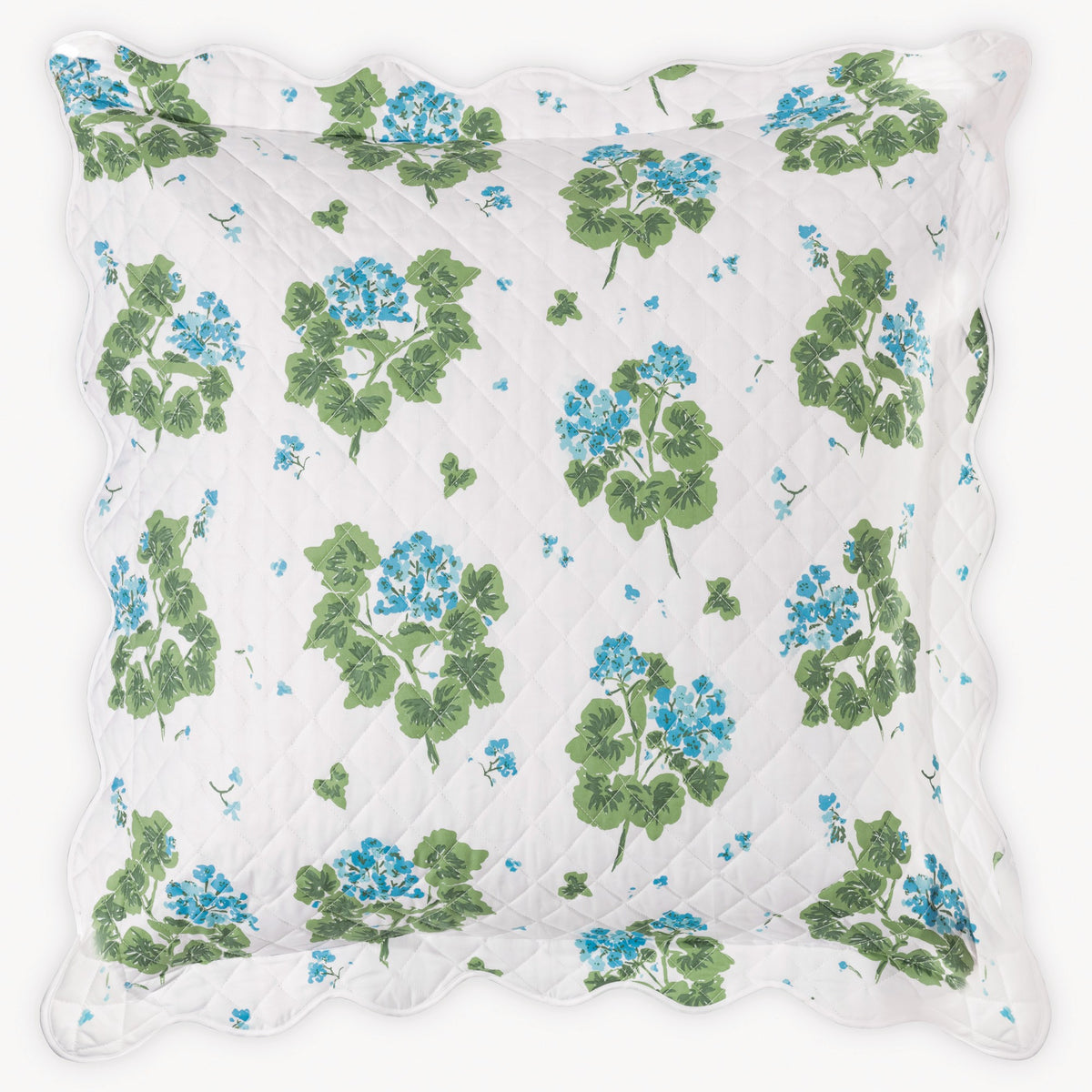 Floral patterned pillow with green leaves and blue flowers on a white background