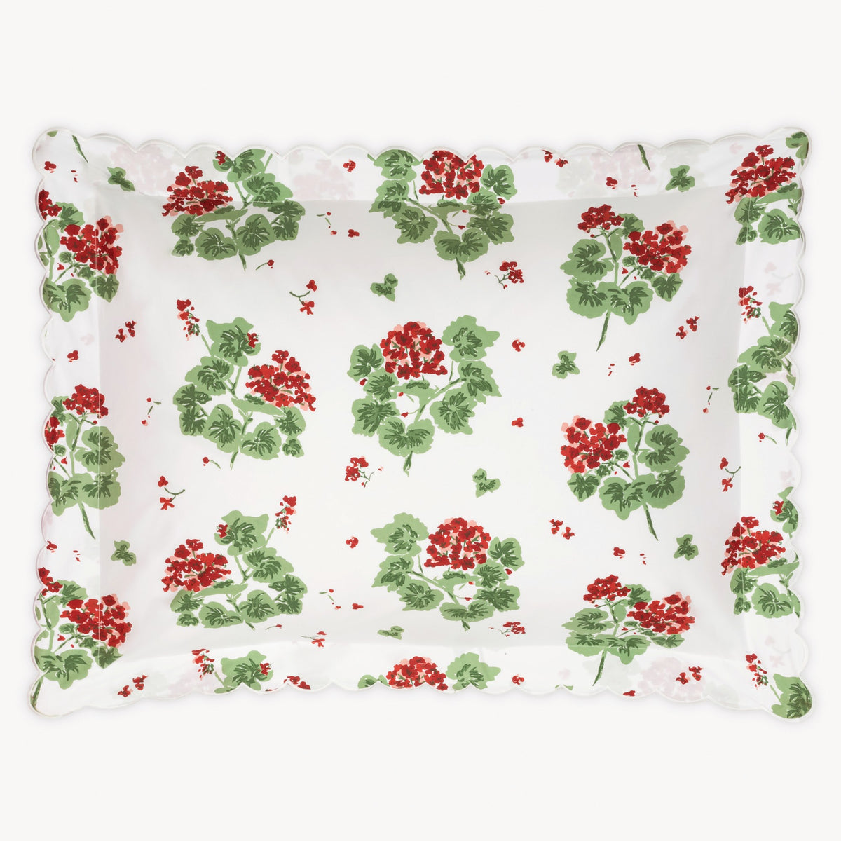 Floral patterned pillow with red flowers and green leaves on a white background