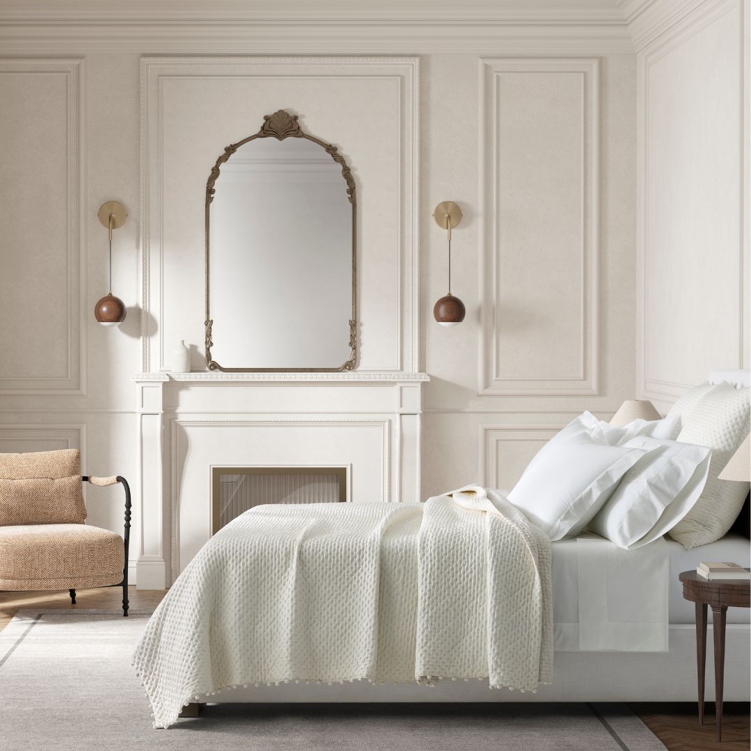 Matouk Margaret Bedding in Abalone in a bedroom with a fireplace and large mirror