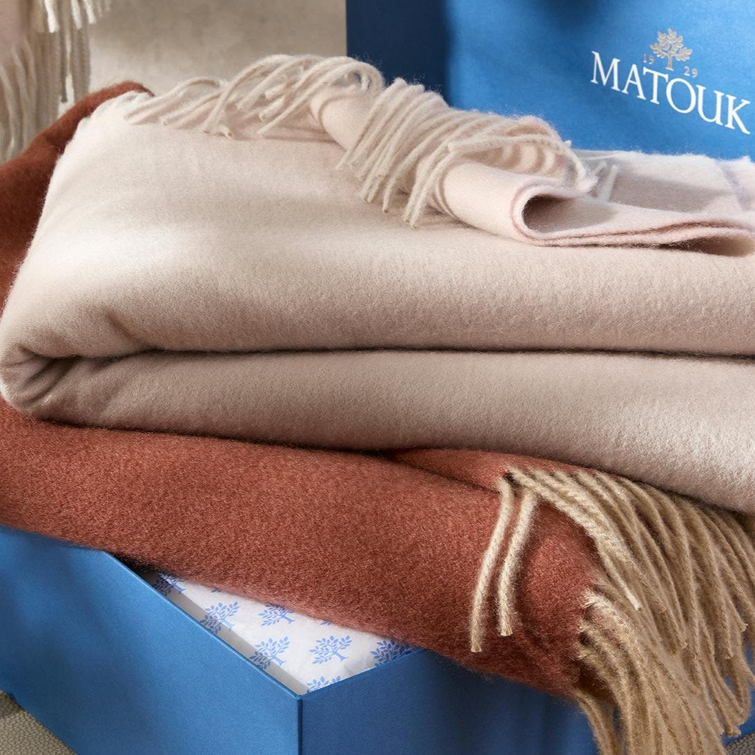 Matouk Paley Throw on top of a gift box