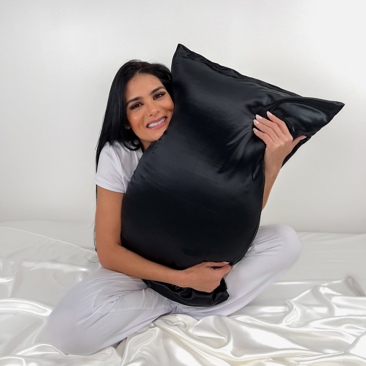 Woman Hugging a Mulberry Park Silks Deluxe 19 Momme Pure Silk Pillowcase in Black Color