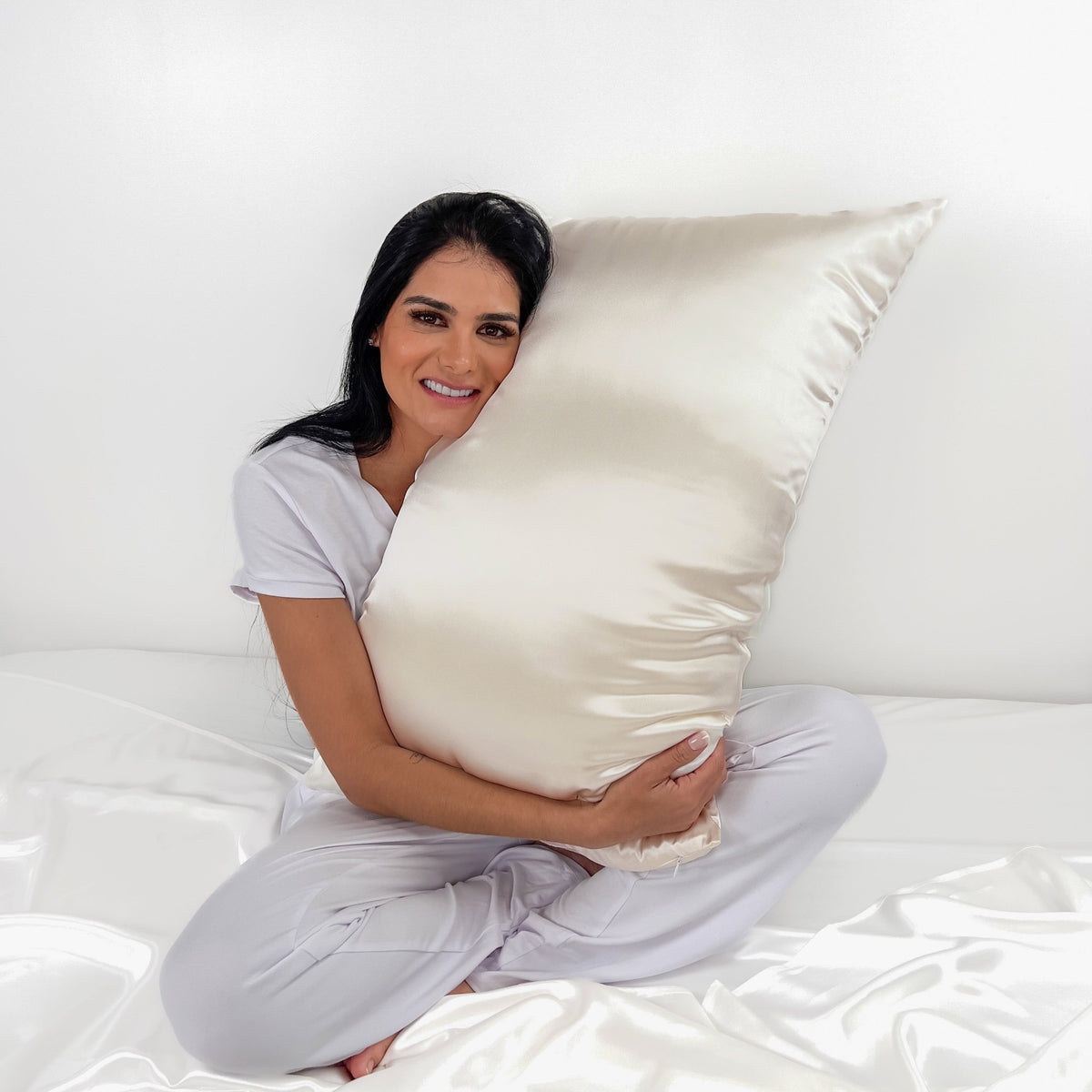 Woman Hugging a Mulberry Park Silks Deluxe 19 Momme Pure Silk Pillowcase in Ivory Color