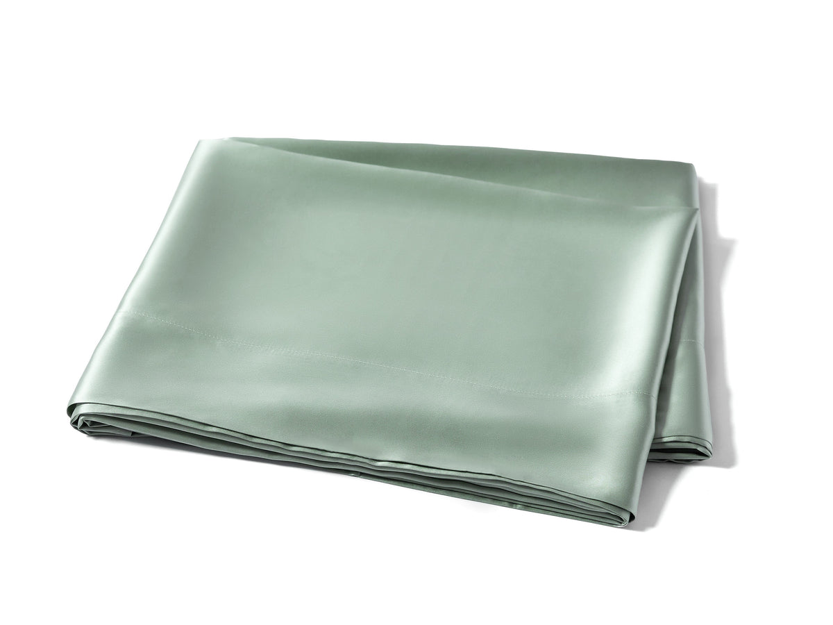 Folded sage silk flat sheet showcasing its smooth texture and high-quality fabric